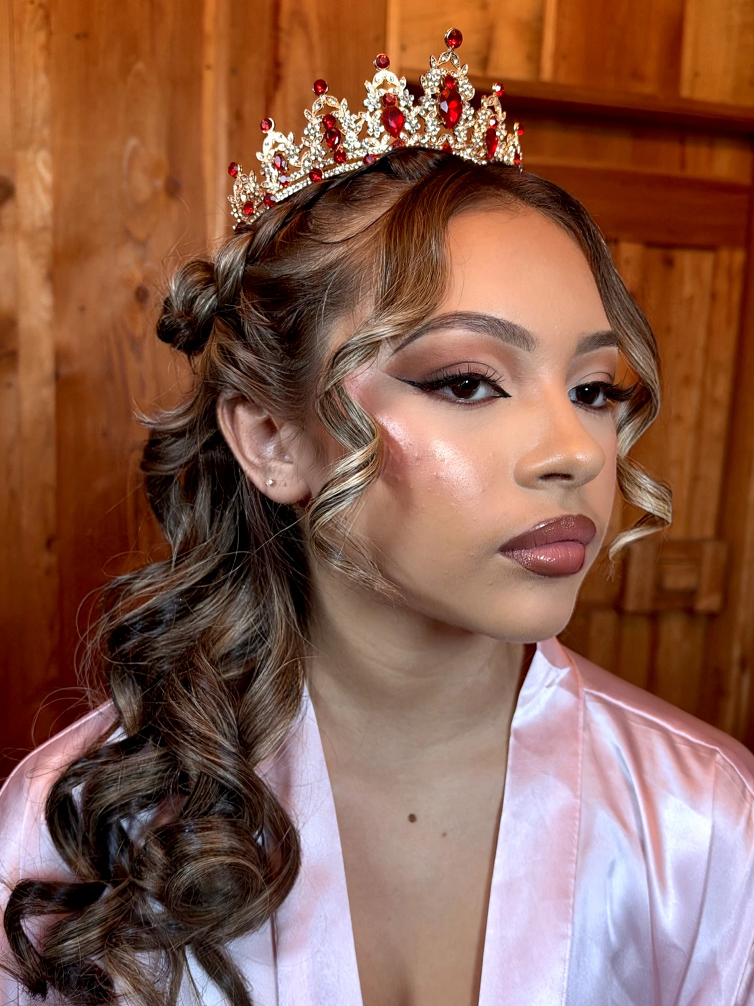 Quinceanera makeup and half-up curls under a jeweled tiara, side angle